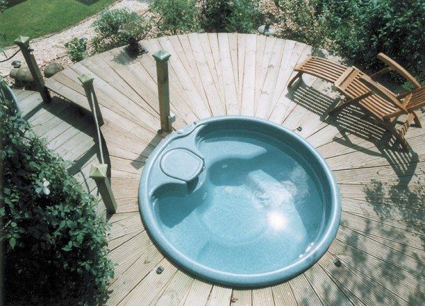 A hot tub is sitting on a wooden deck