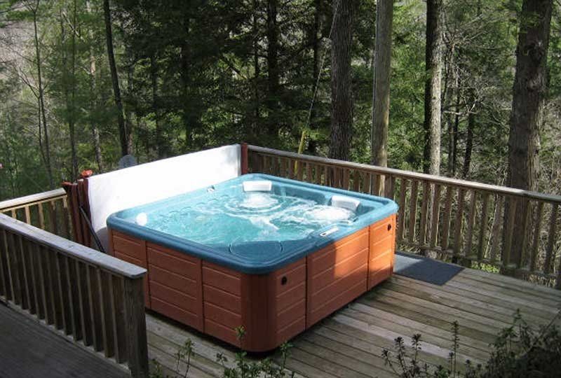 A hot tub on a wooden deck in the woods