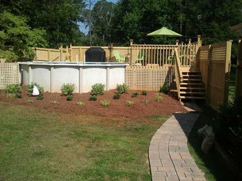 A backyard with a swimming pool and a wooden deck