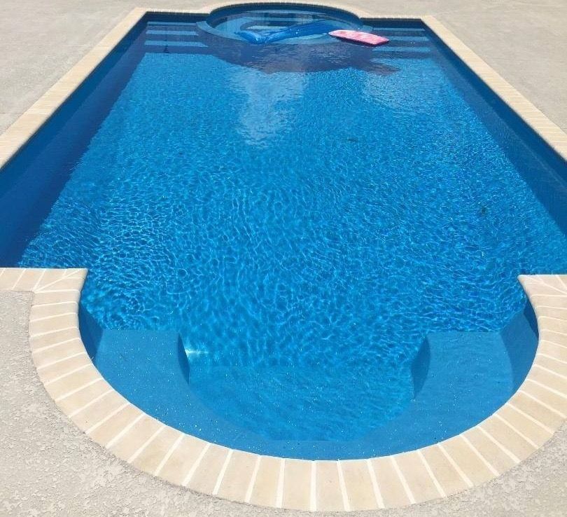 A large blue swimming pool with a pink float in it