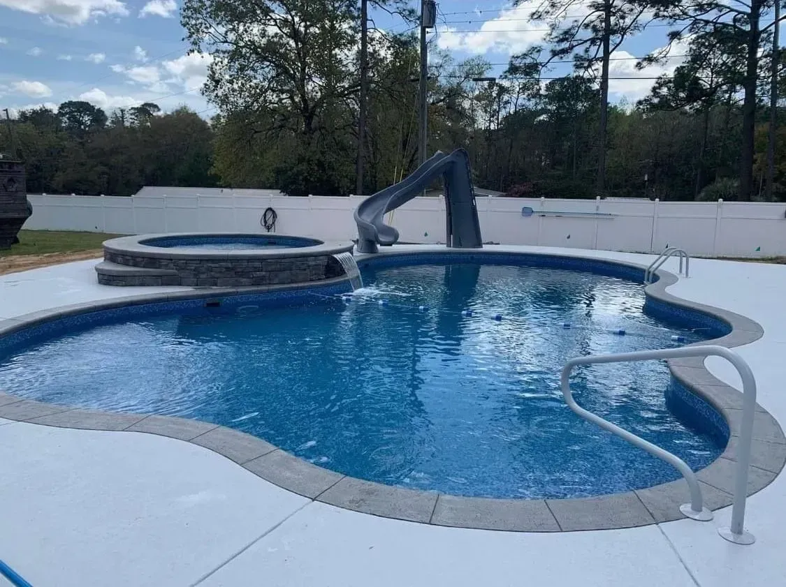 A large swimming pool with a slide attached to it.