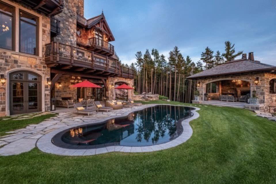 A large house with a large swimming pool in front of it.