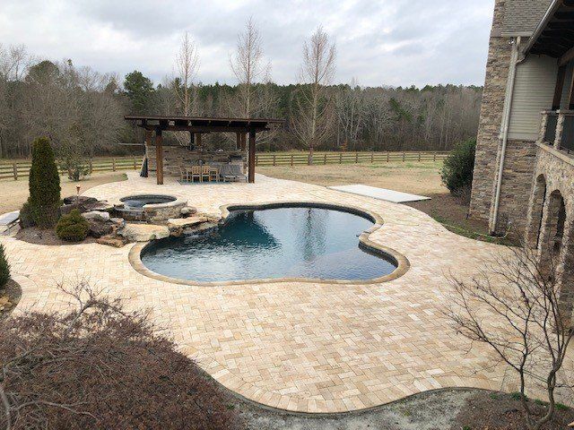 There is a large swimming pool in the backyard of a house.