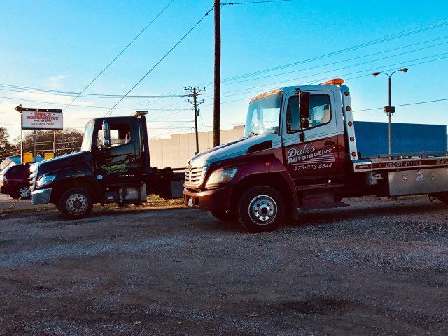 Two tow trucks are parked next to each other in a parking lot.