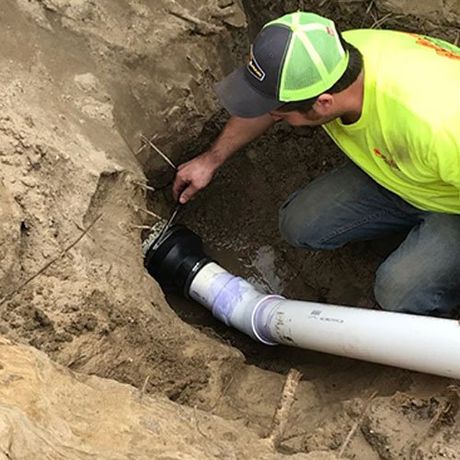 Man Repairing Home Drainage Under the Ground — Port Huron, MI — Dynamic Drain Services