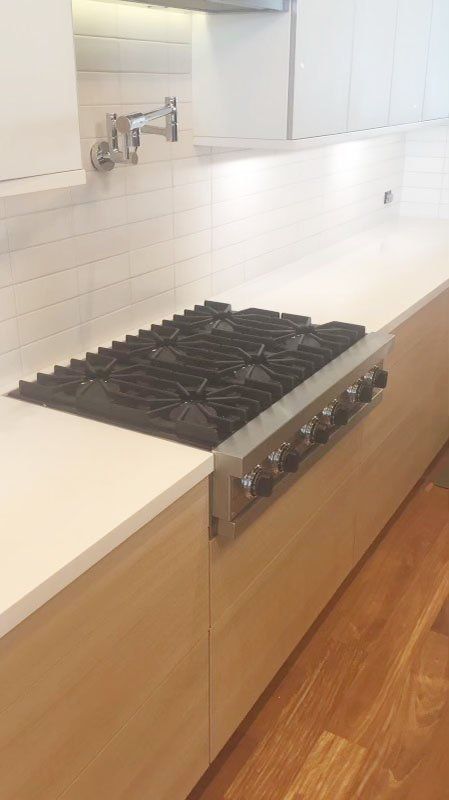 Wall mount pot filler and integrated cooktop