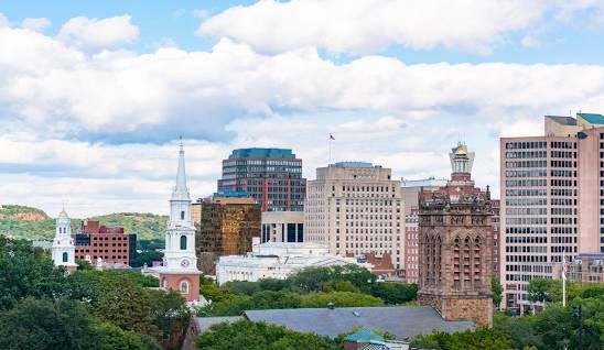A city skyline with a lot of buildings and trees in the foreground.