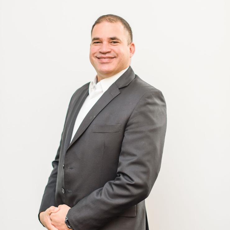 A man in a suit and white shirt is smiling for the camera