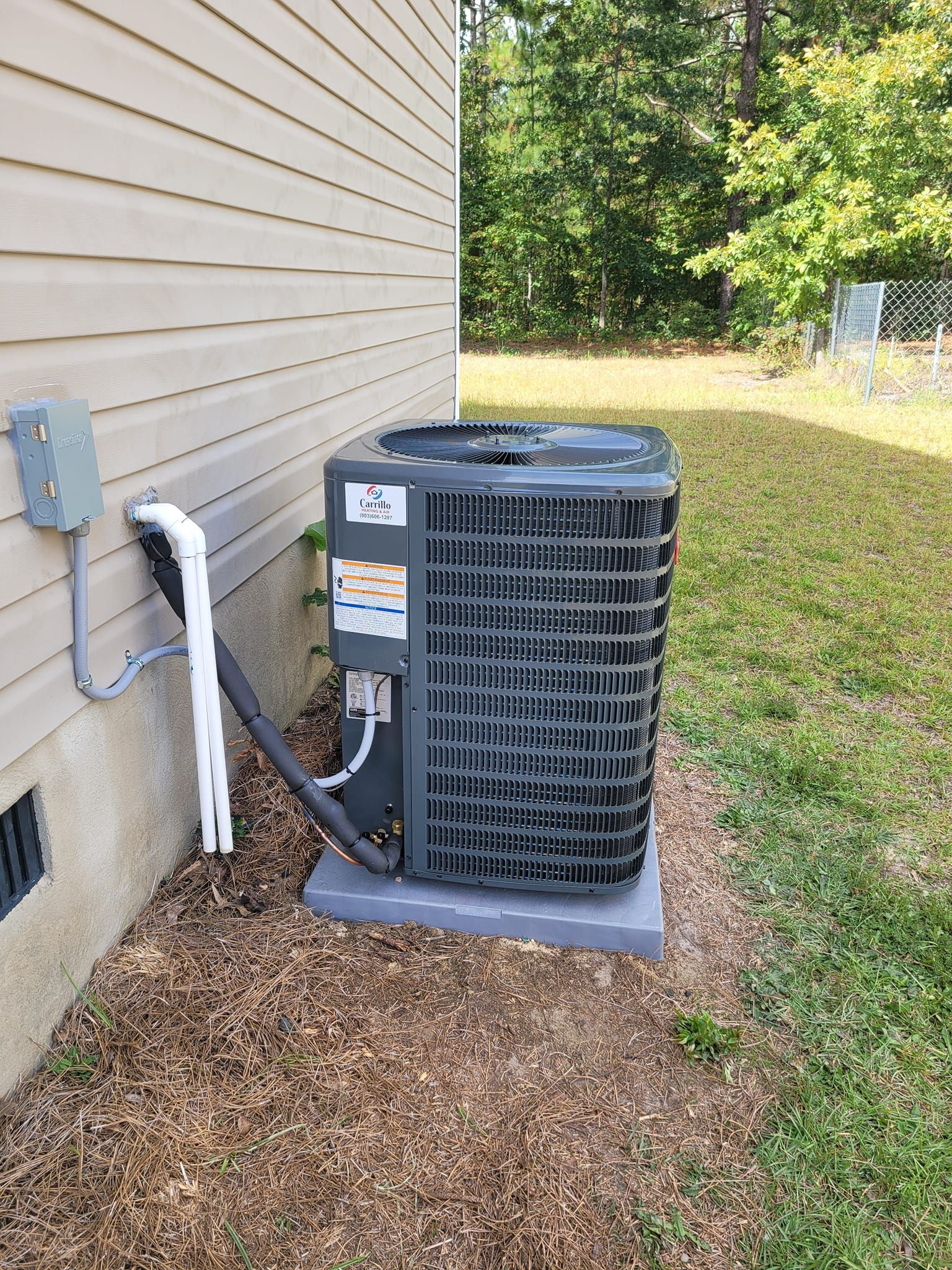 An air conditioner is sitting on the side of a house.
