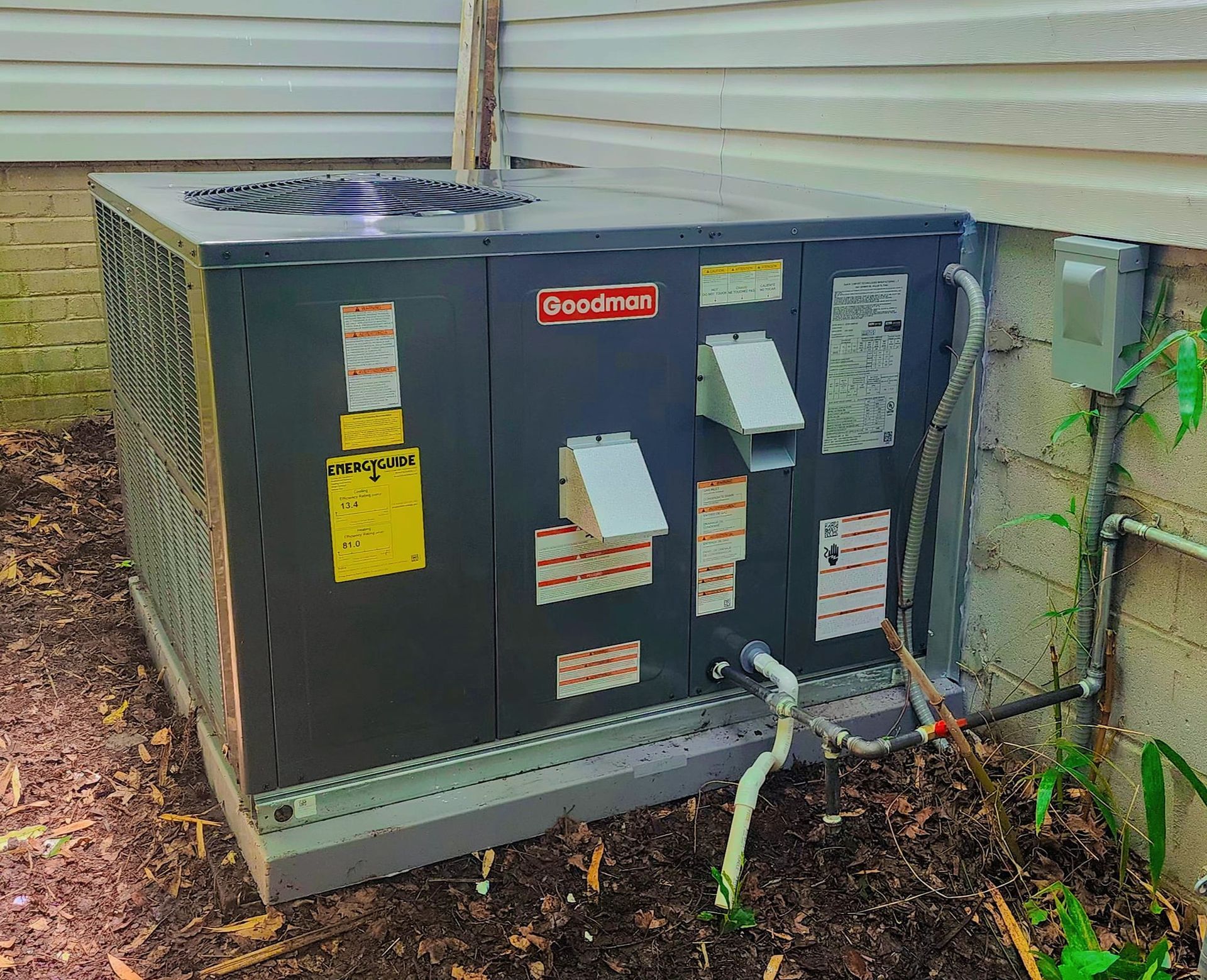 A large air conditioner is sitting outside of a house.