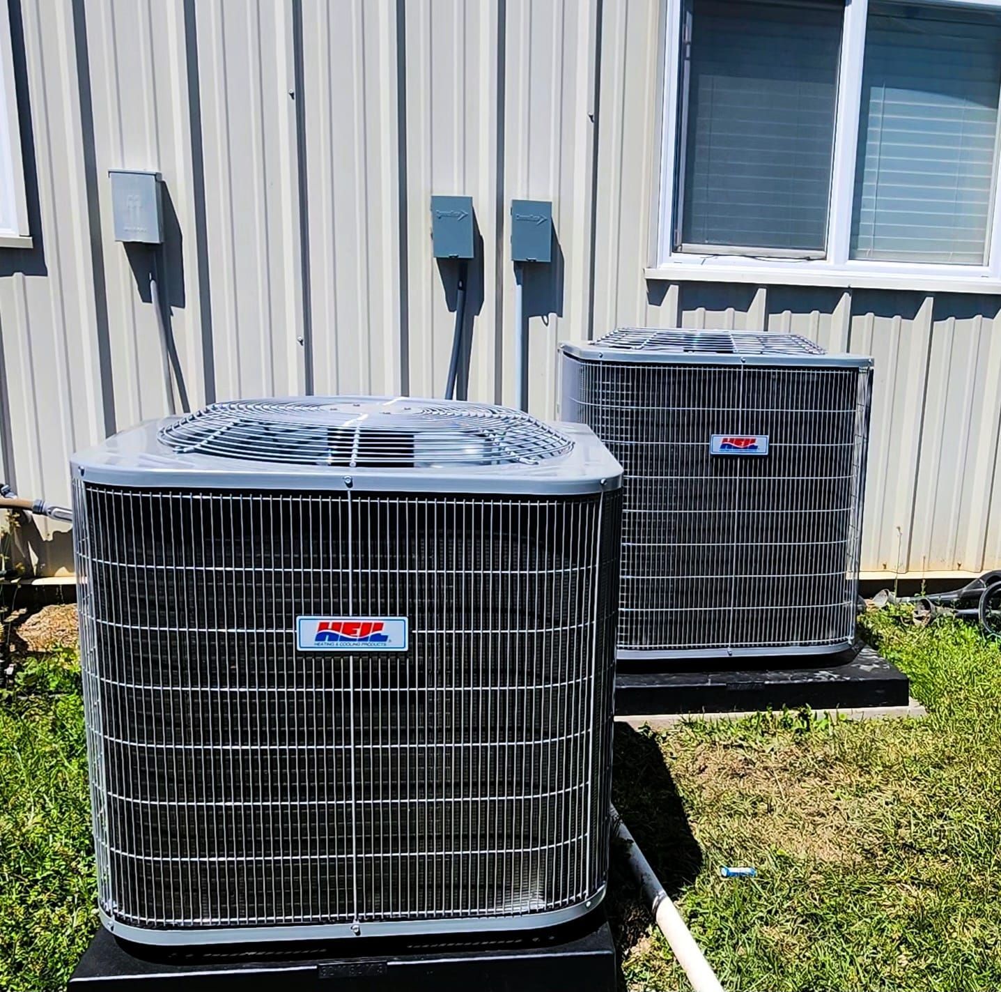 Two air conditioners are sitting outside of a building
