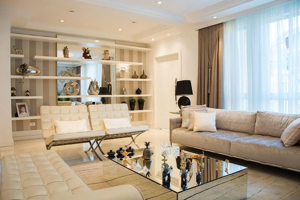 A living room with a couch , chairs , and a coffee table.