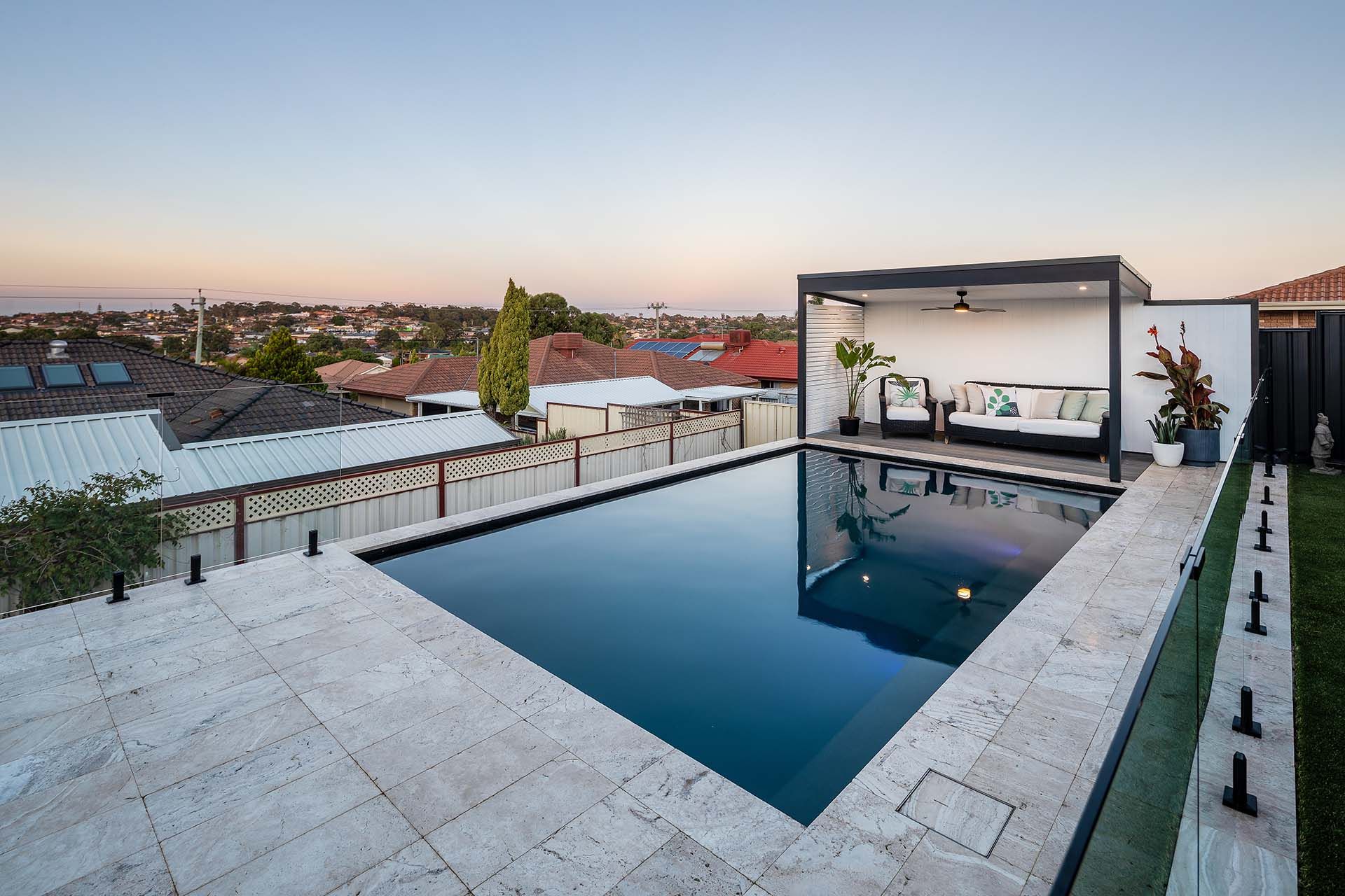 A large swimming pool with a pergola in the background