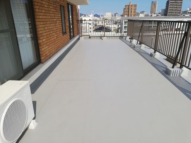 A mostly empty balcony with brick walls and concrete floors