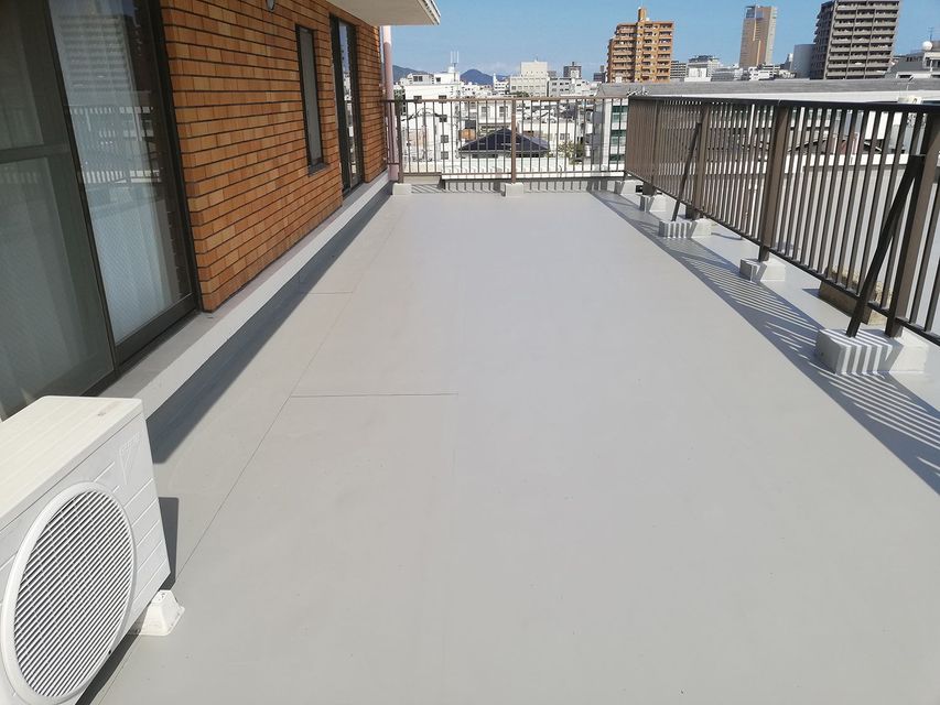 A mostly empty balcony with brick walls and concrete floors