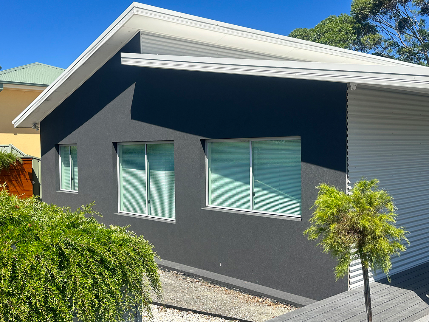 A house with multiple windows and a tree in front of it