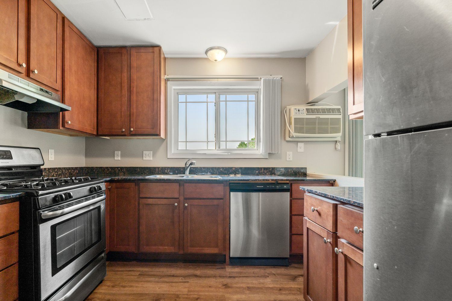 A kitchen with stainless steel appliances and wooden cabinets
