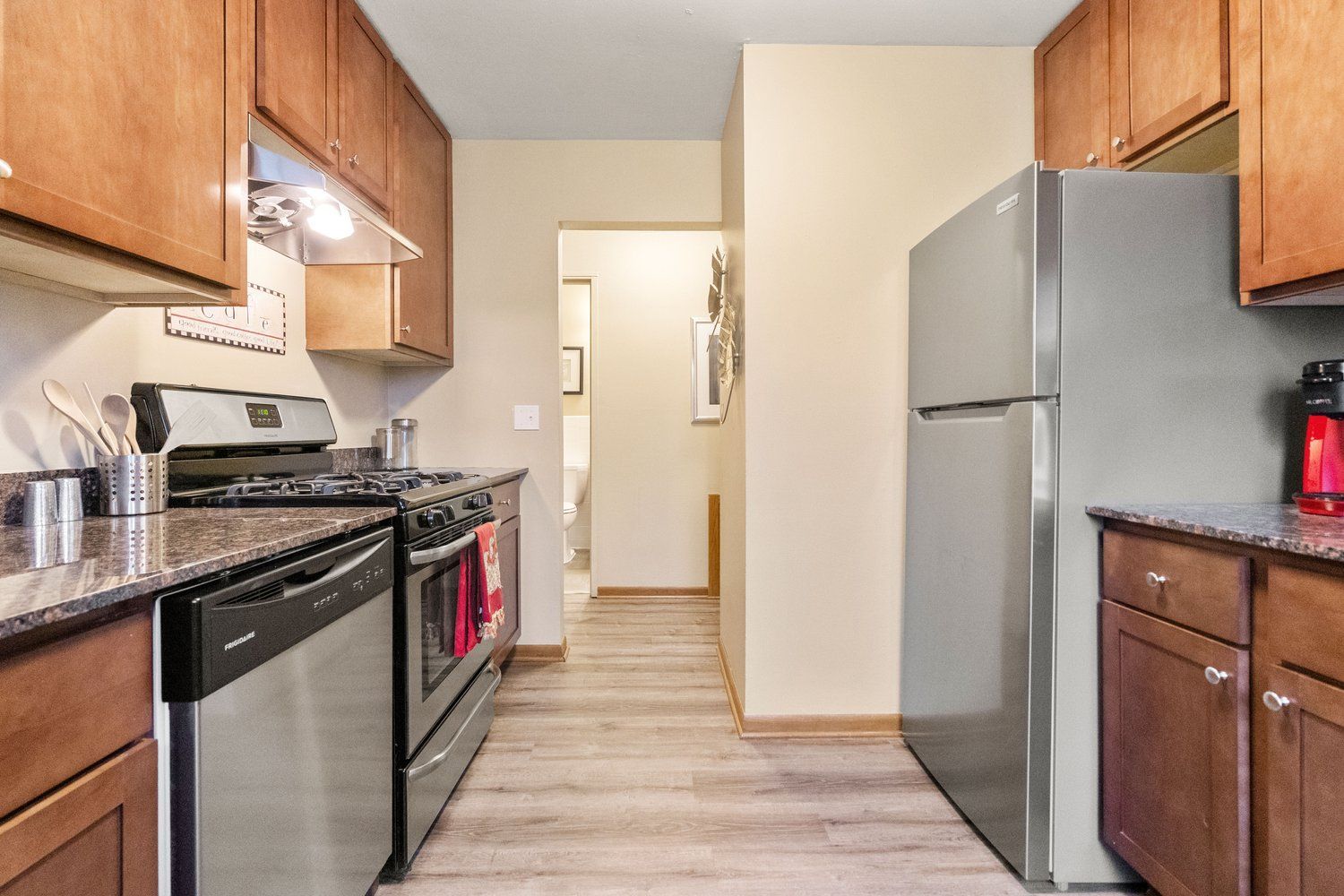 A kitchen with stainless steel appliances and wooden cabinets