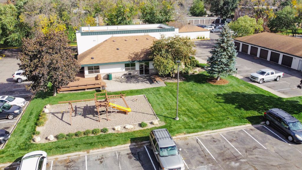 An aerial view of a park with a playground and a building in the background.