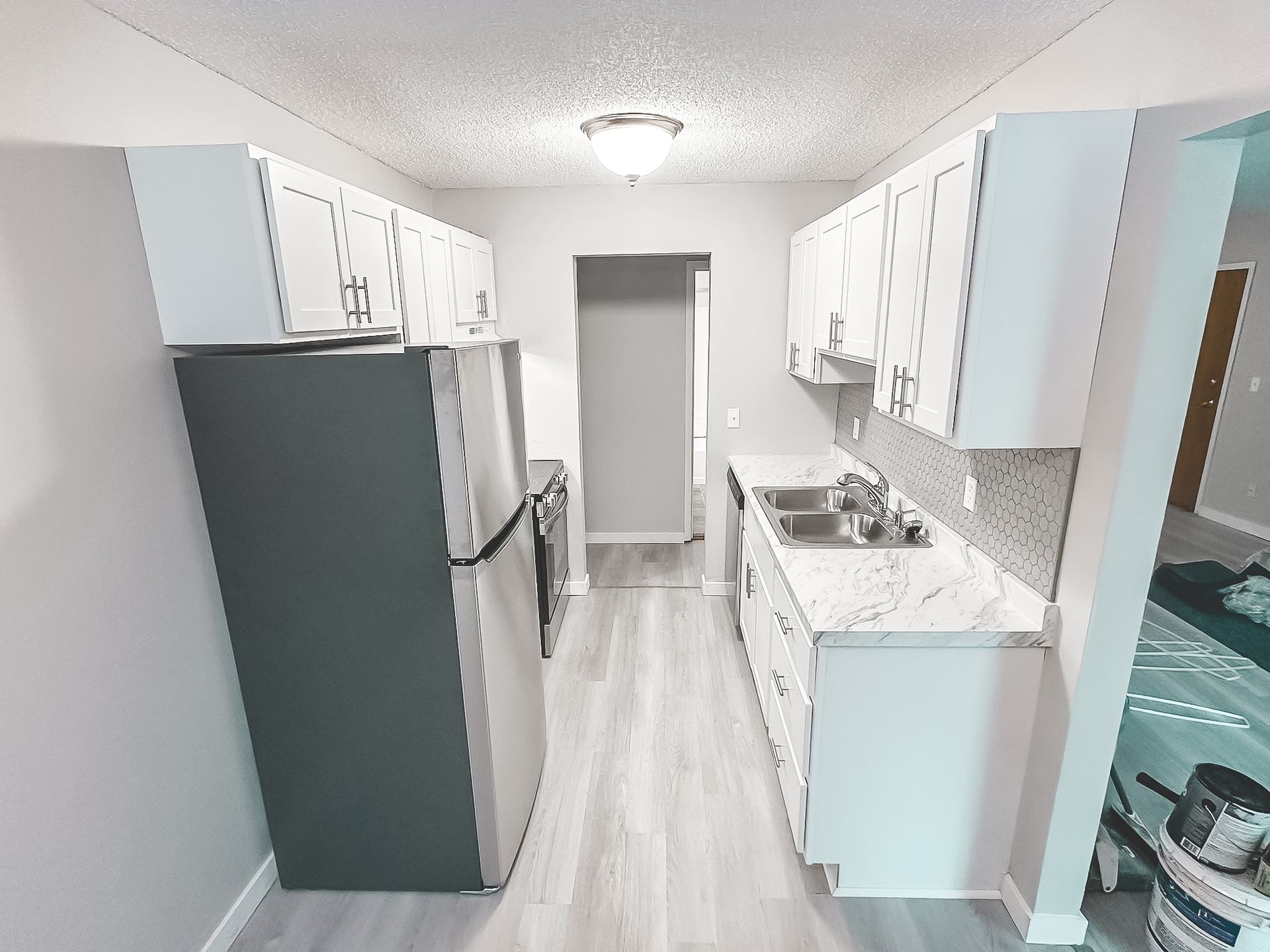 A kitchen with white cabinets and stainless steel appliances
