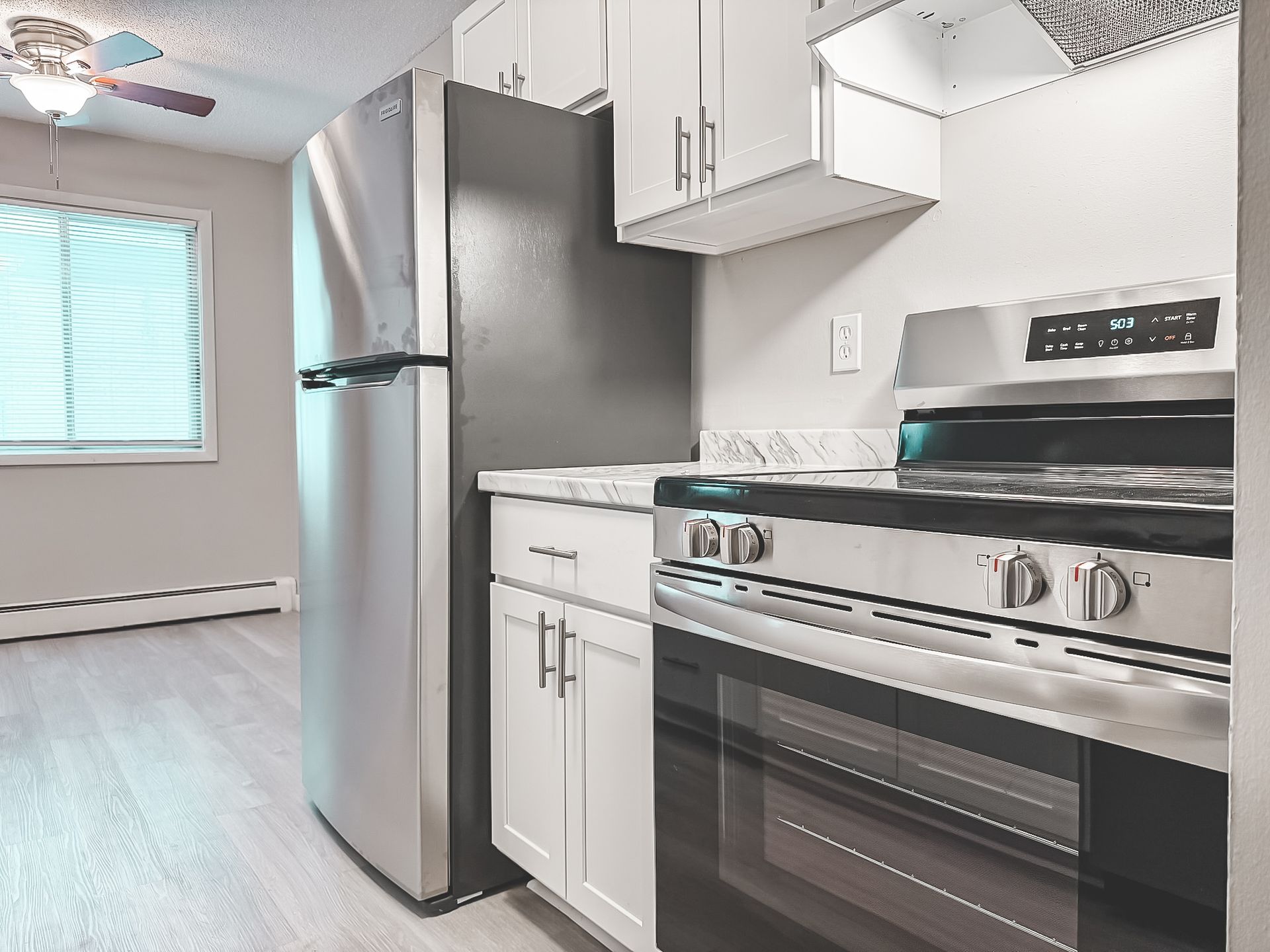 A kitchen with stainless steel appliances and white cabinets