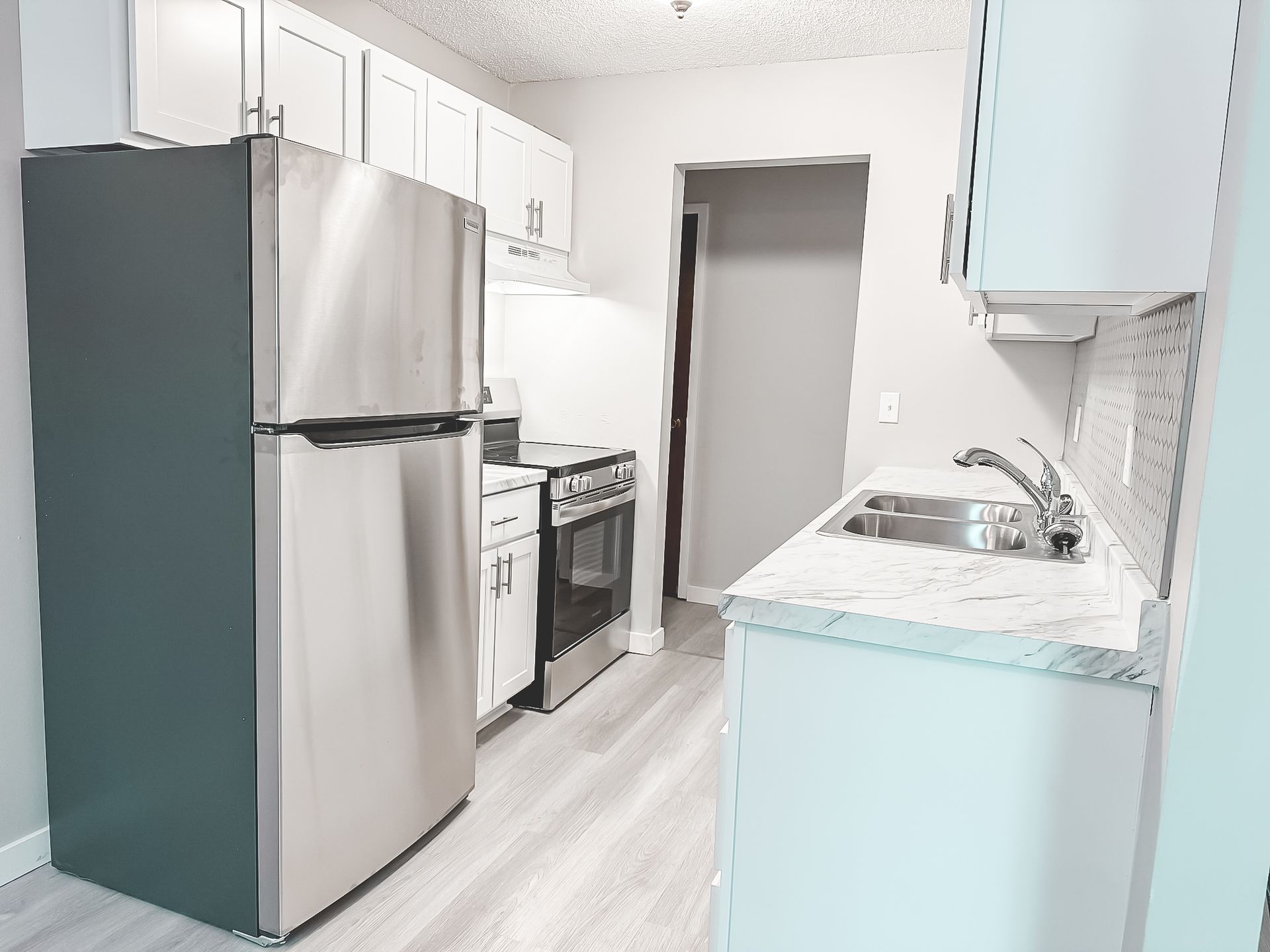 A kitchen with stainless steel appliances and white cabinets