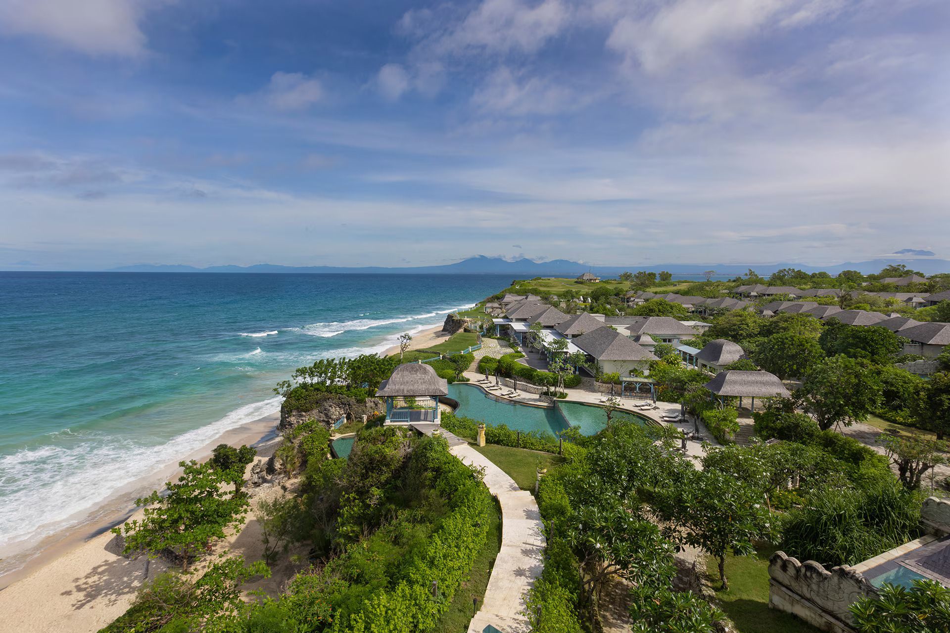 An aerial view of a resort on a cliff overlooking the ocean.