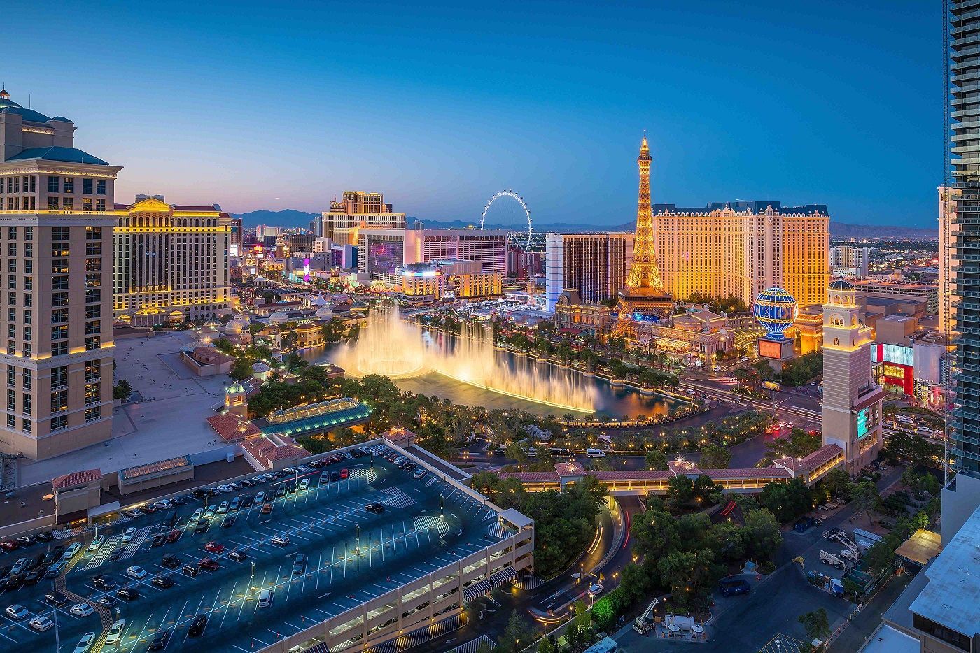 An aerial view of las vegas at night with a fountain in the middle of the city.