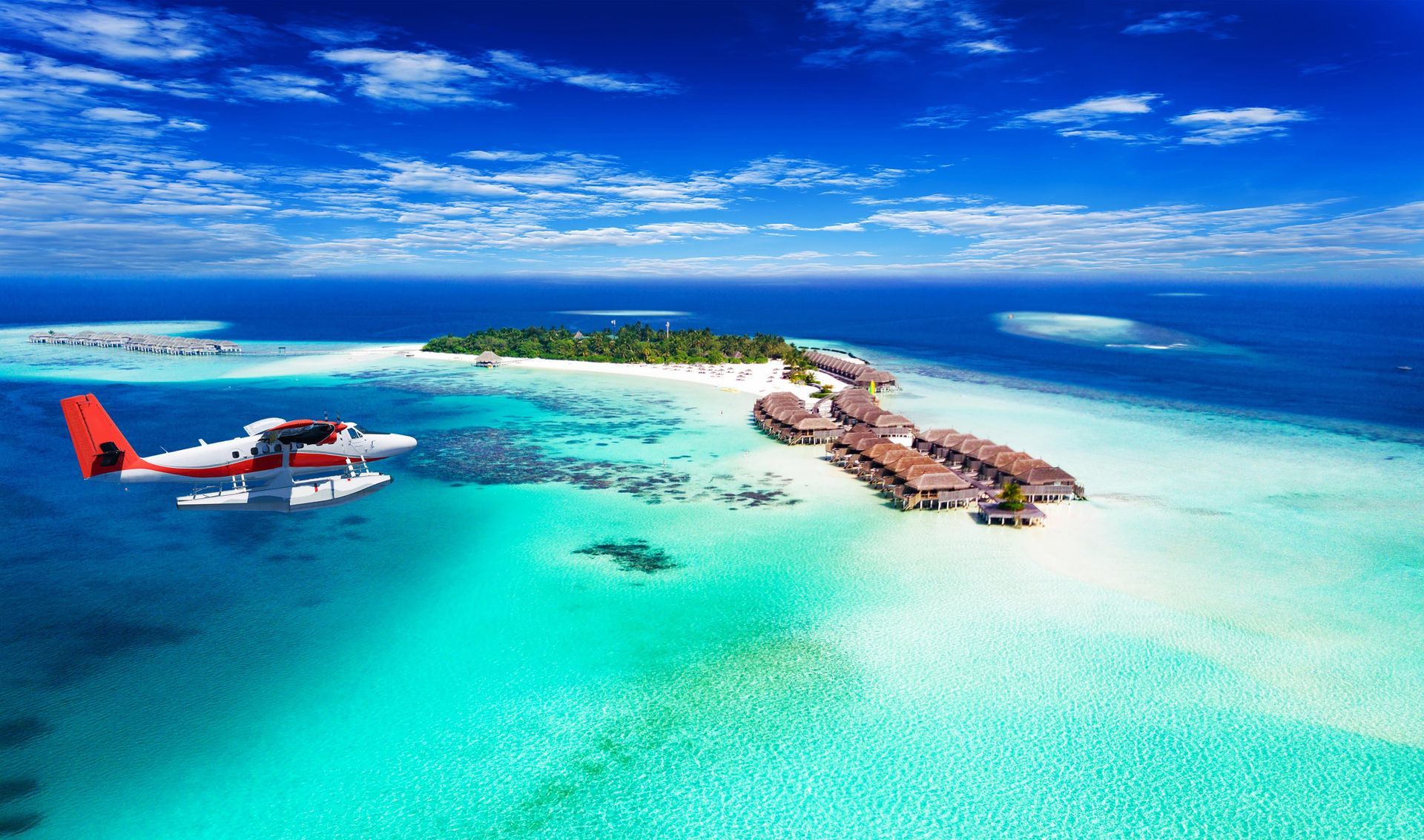 An aerial view of a small plane flying over a tropical island.