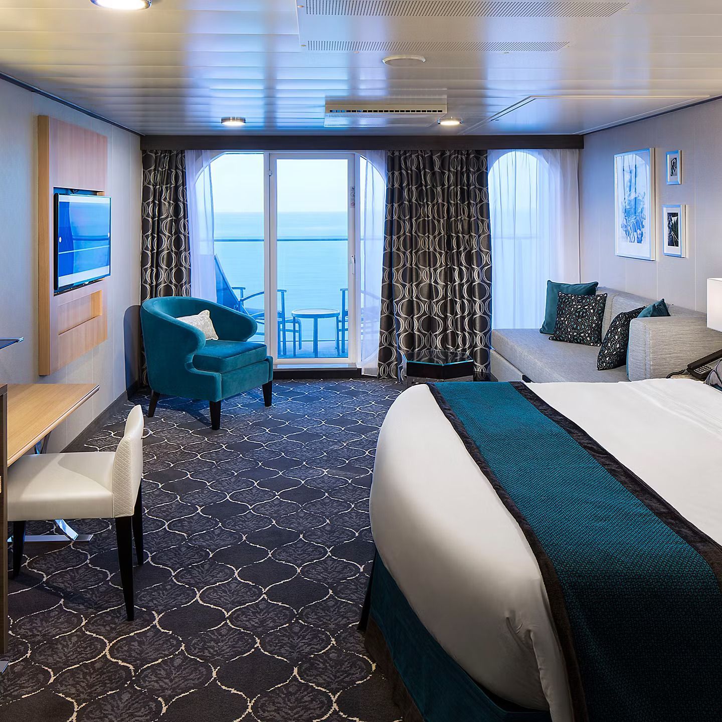 A hotel room with a large bed and a balcony overlooking the ocean