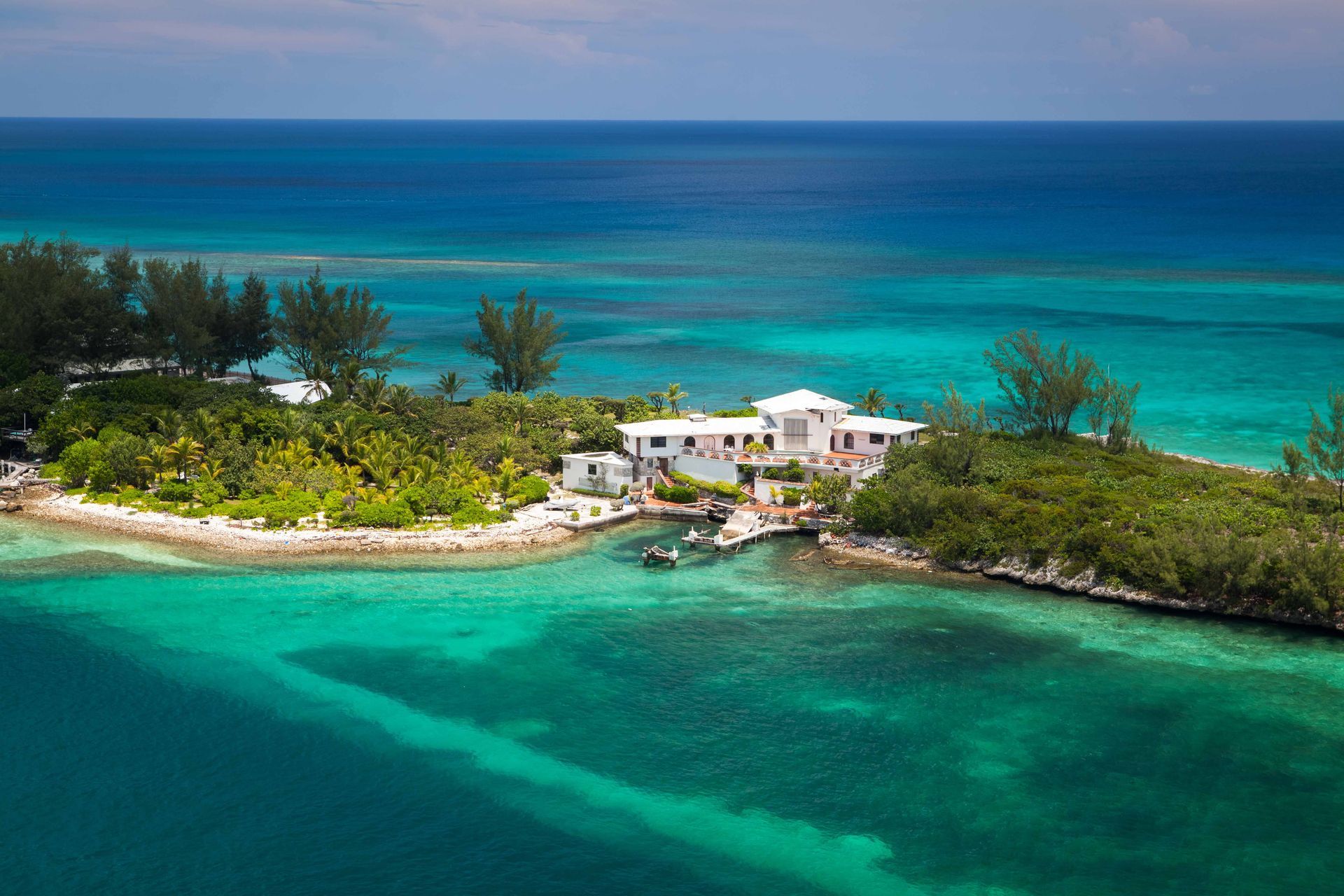 Aerial view of a house on a small island in the Caribbean sea.