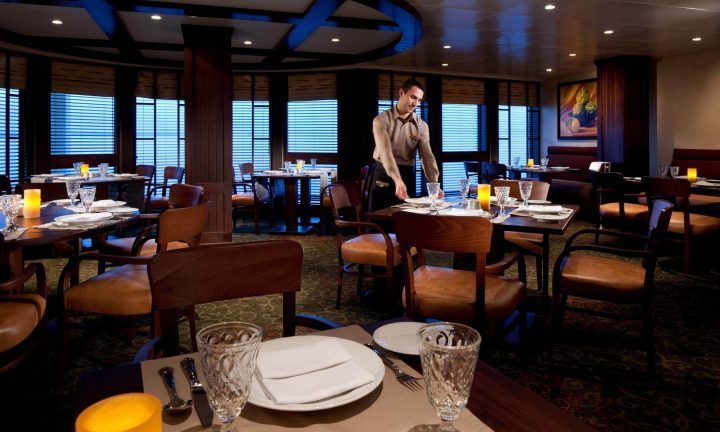 A waiter is setting tables in a restaurant