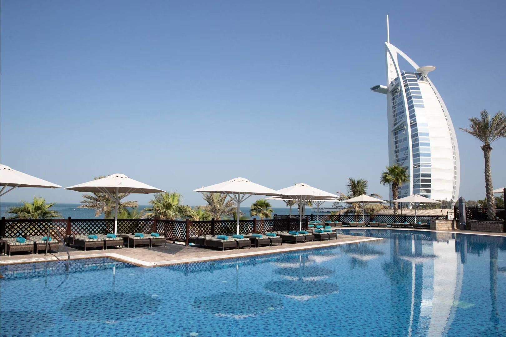 A large swimming pool with a sailboat in the background