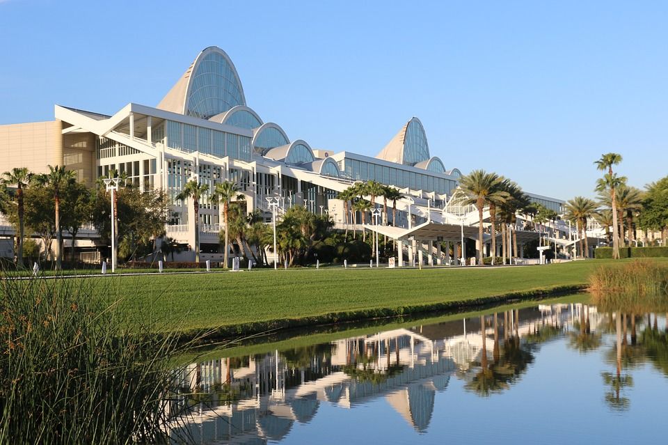 A large building in Orlando is reflected in a body of water.