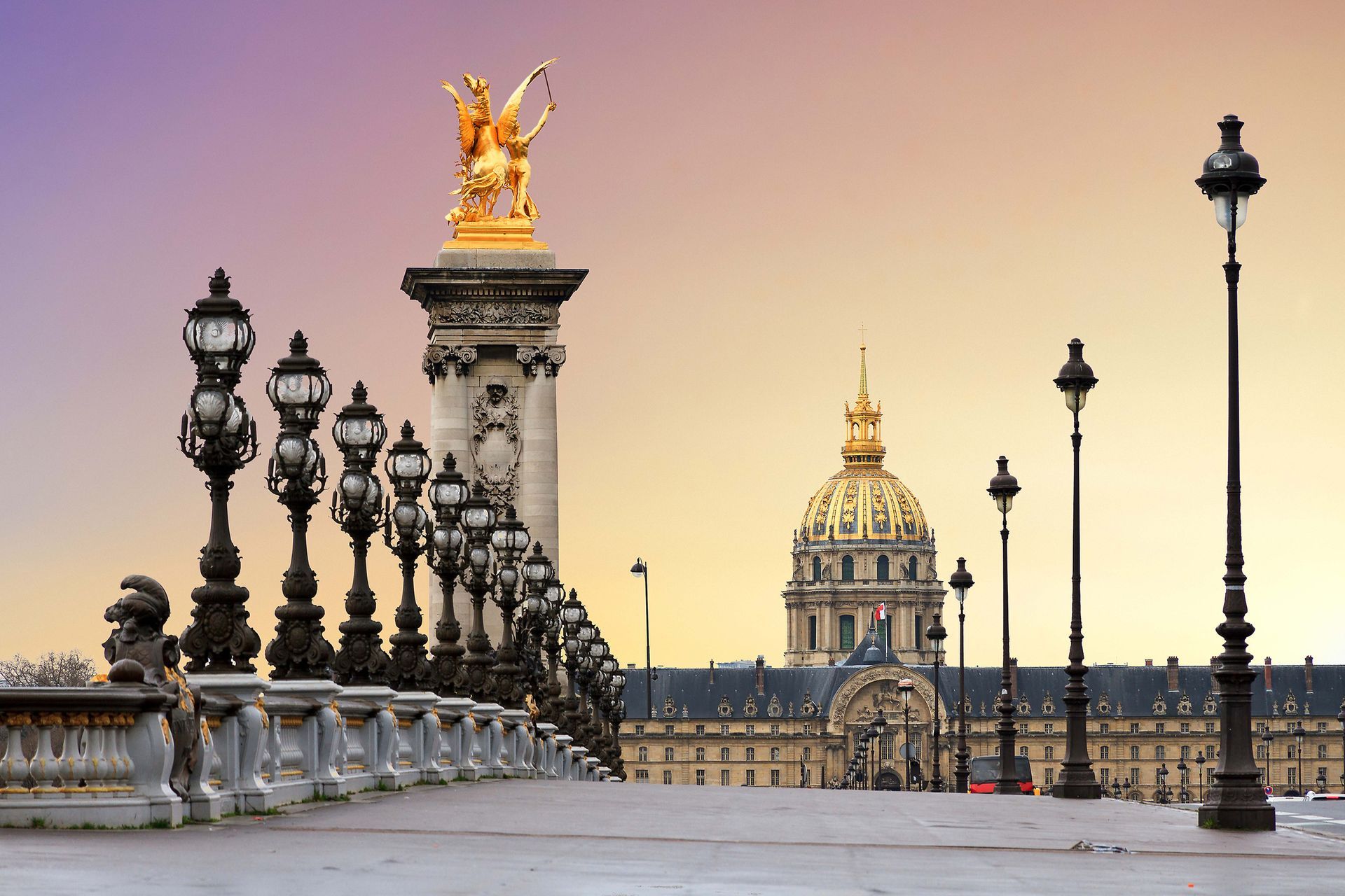 A bridge with a statue on top of it and a building in the background