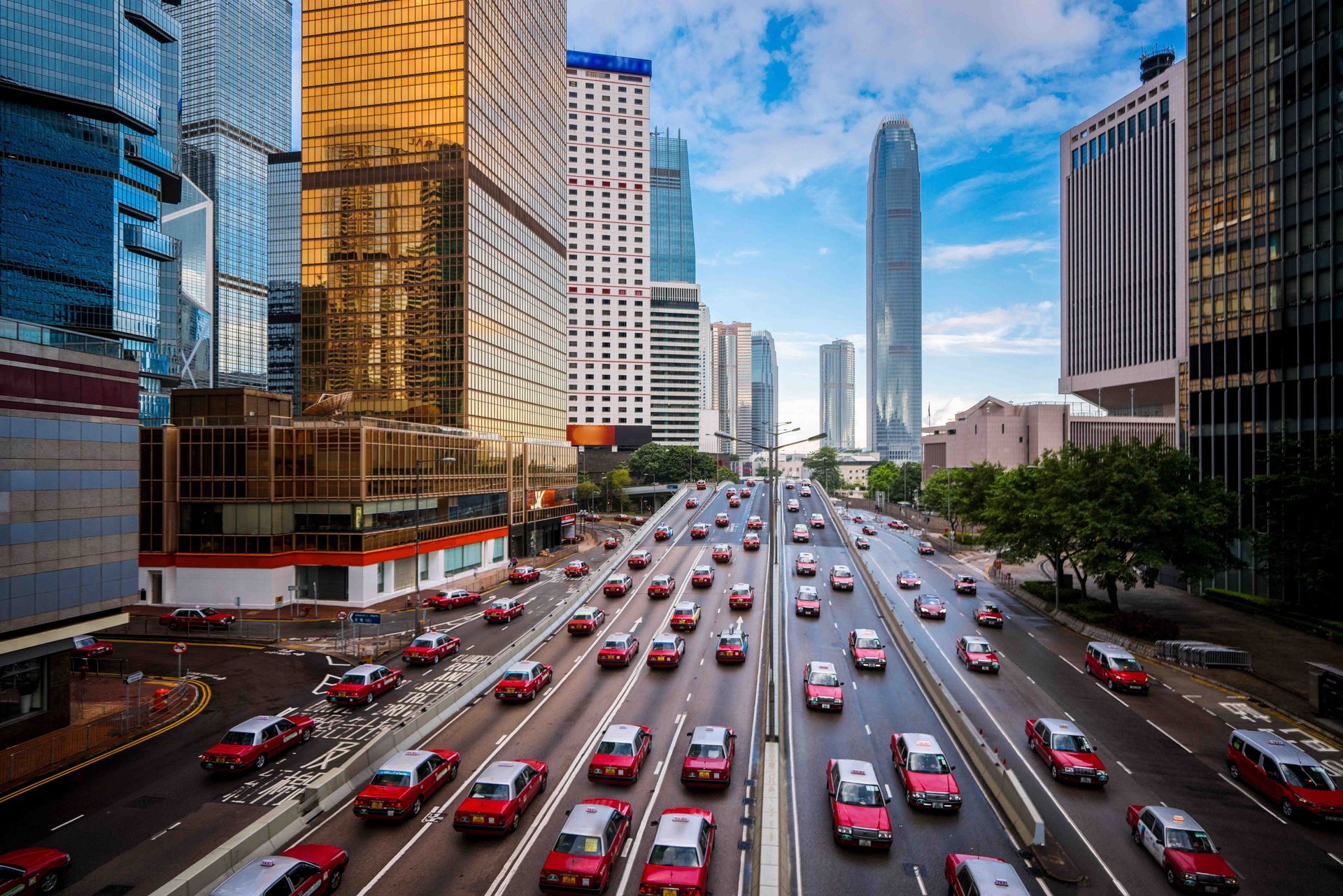 Many red taxis passing through Gloucester Road, a highway in Hong Kong.