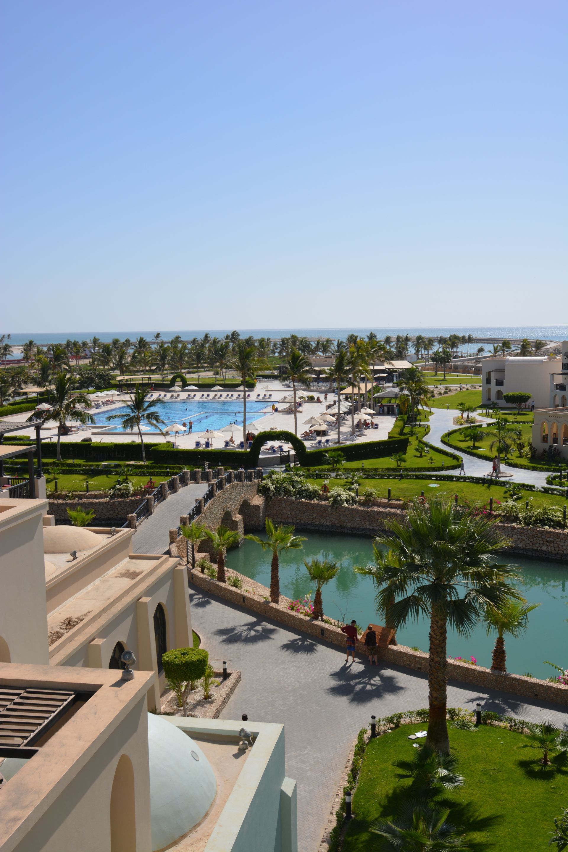 An aerial view of a resort with a pool and palm trees
