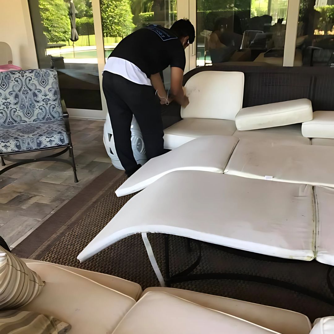 A man in a black shirt is working on a couch