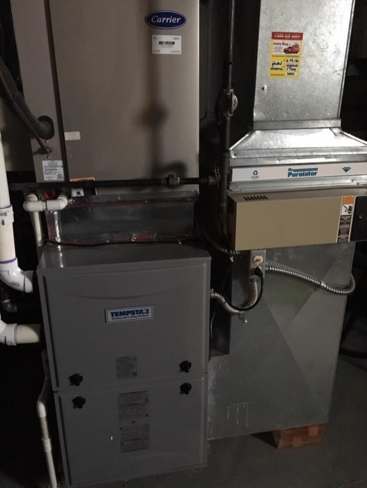 Gray furnace and air handler with ductwork and Carrier branding.