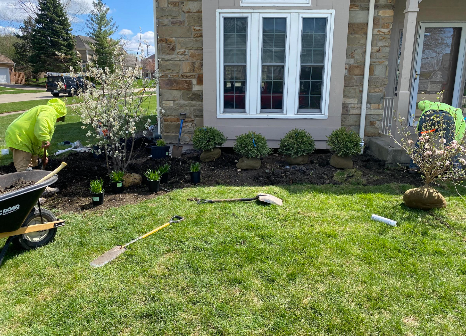 A man is working on a lawn in front of a house.