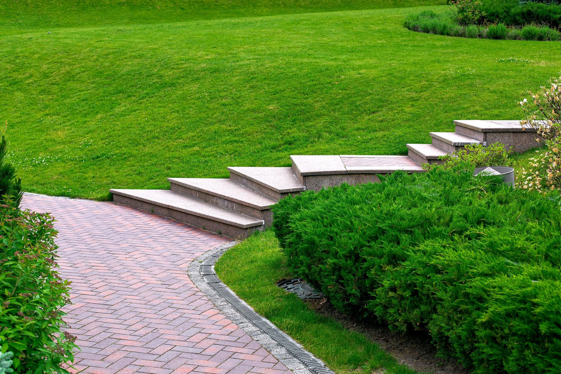 A large blue and white house with a brick walkway leading to it.
