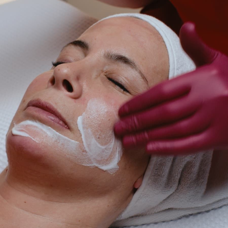 CIDESCO-certified beautician Julia Hediger applies face cream to a client during a facial treatment.