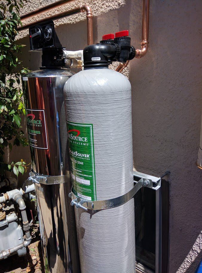A water filter is sitting on the side of a building.