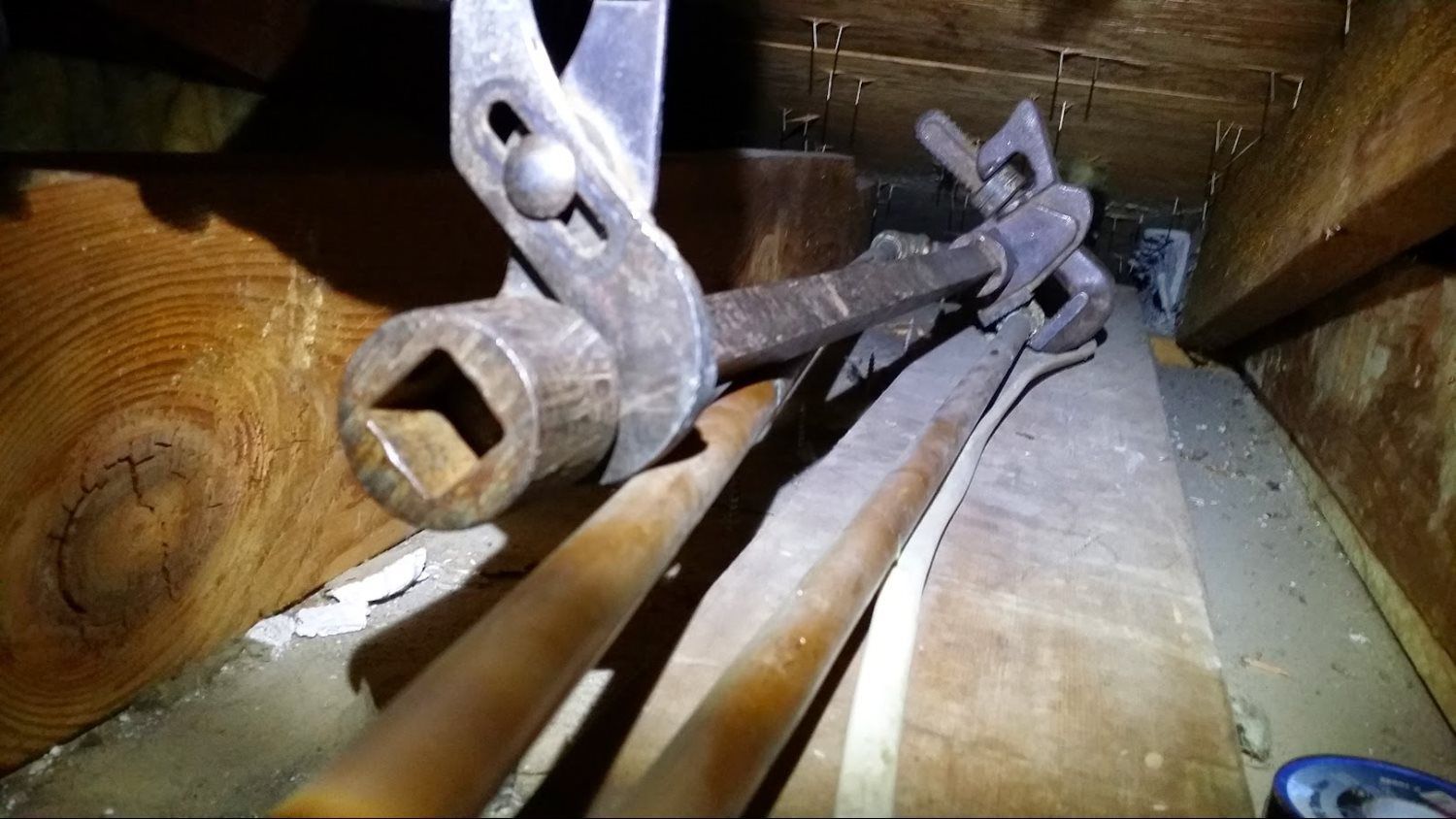 A close up of a rusty object in a wooden room.