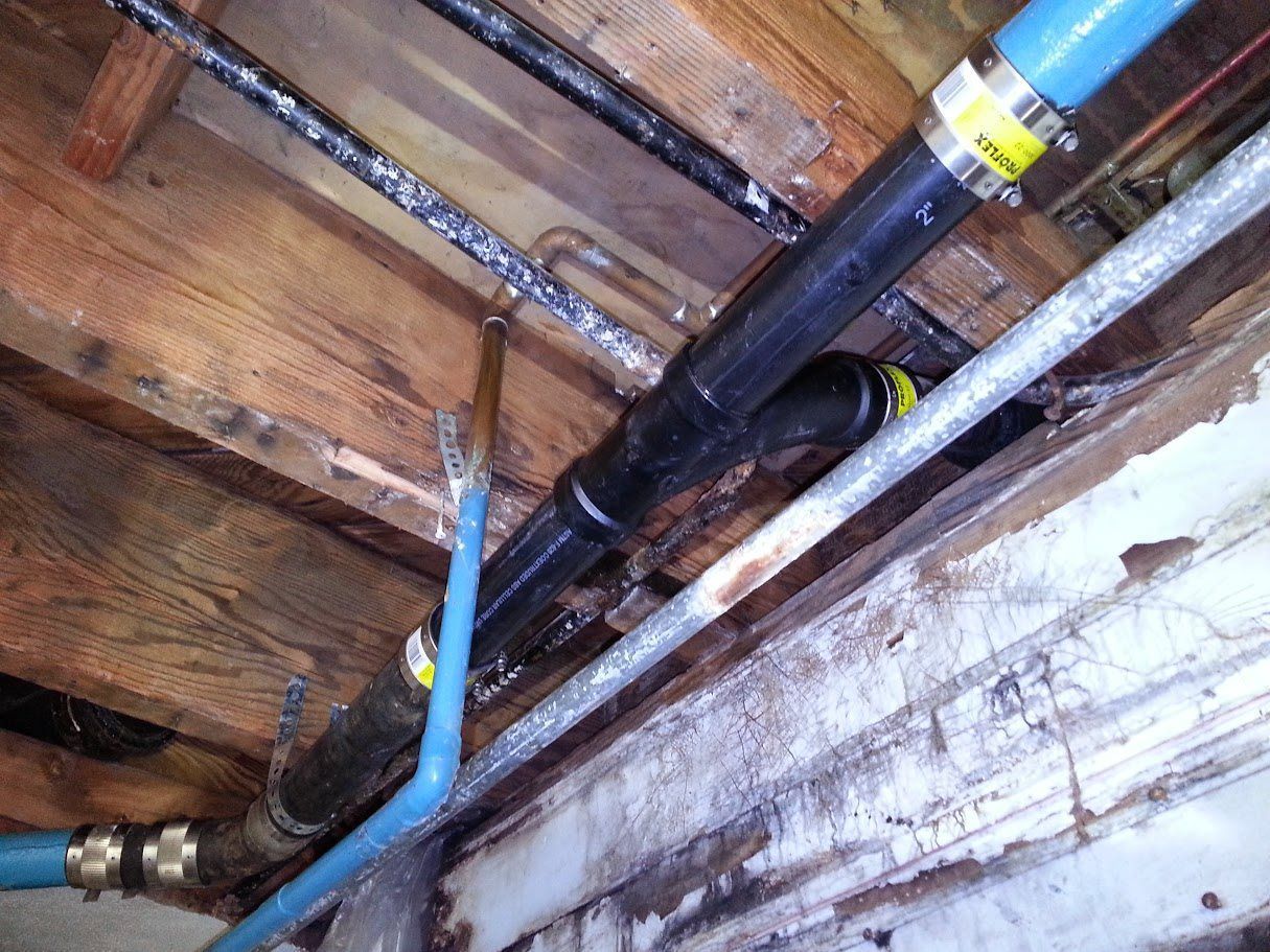 A bunch of pipes are hanging from the ceiling of a building.