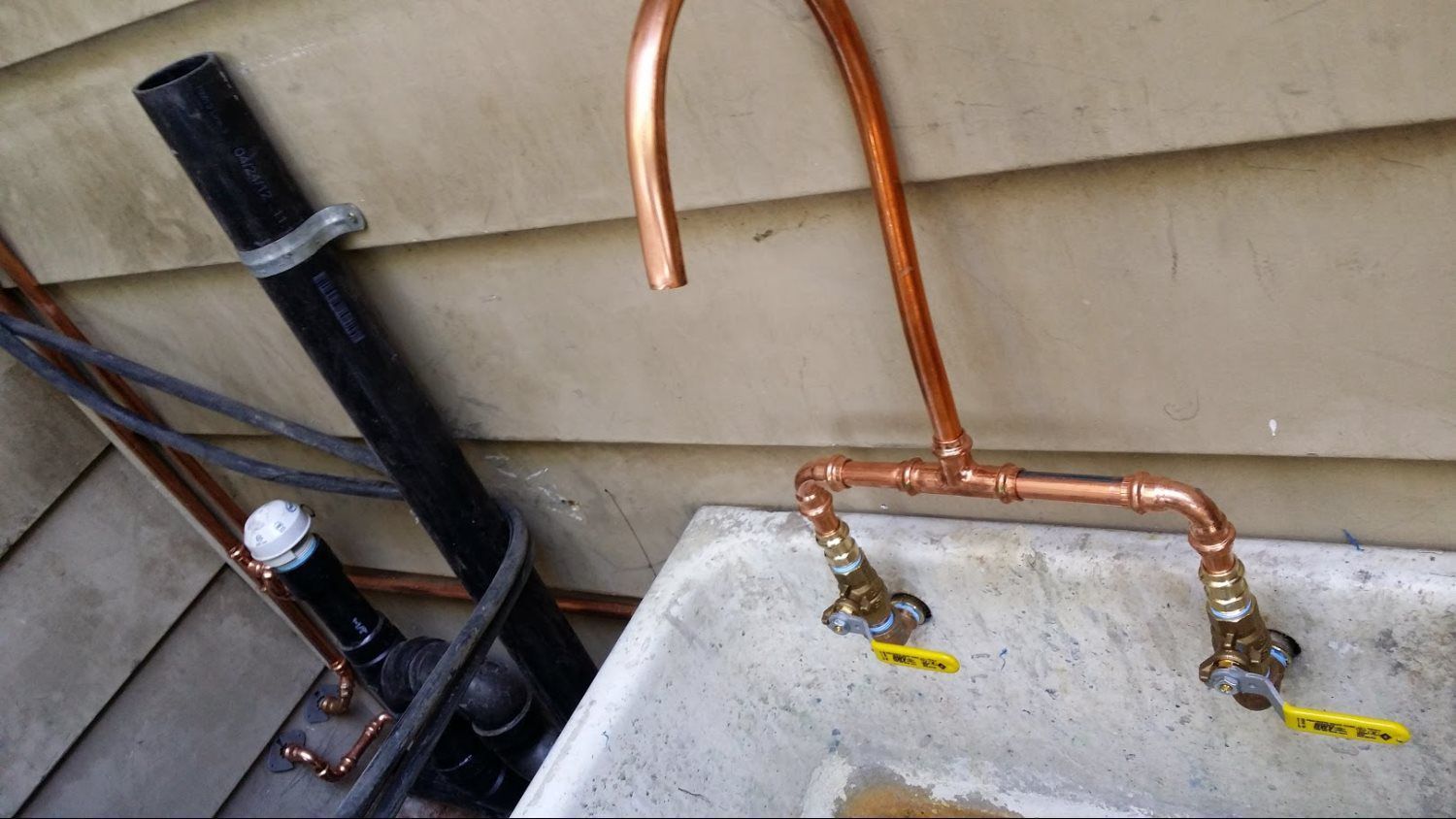 A sink with copper pipes attached to it