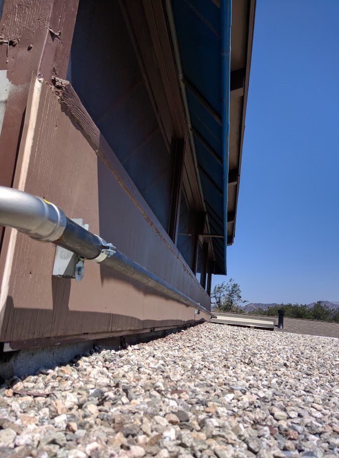 A pipe is attached to the side of a building
