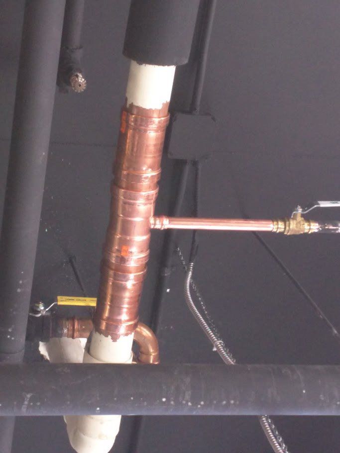 A copper pipe with a white pipe attached to it