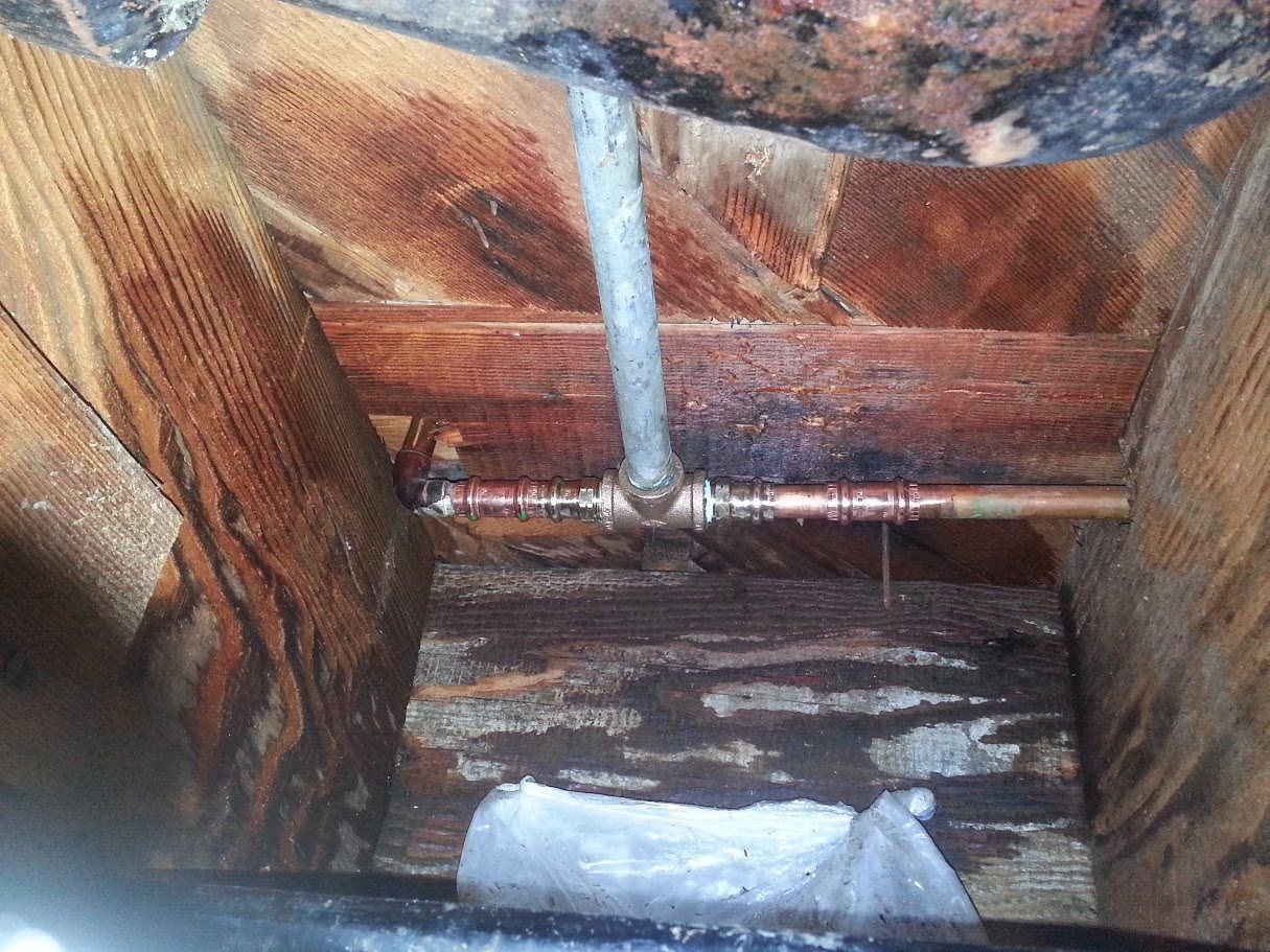 Water is coming out of a pipe in a wooden box.