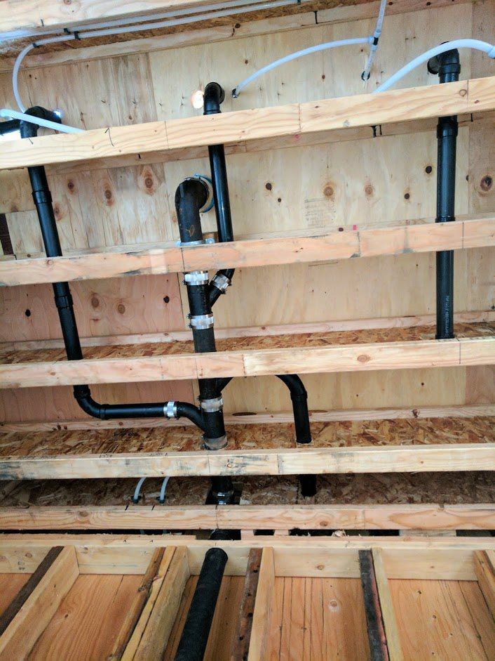 A bunch of pipes are hanging from the ceiling of a building.